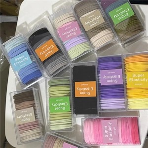 Close-up of colorful high-elasticity towel fabric hair ties in a transparent storage box