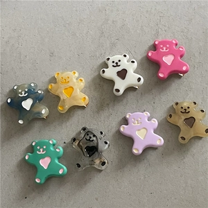 Lot de huit barrettes ours en acrylique coloré avec détails coeur sur fond gris texturé
