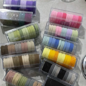 Close-up of assorted colorful high-elastic hair ties in transparent storage boxes