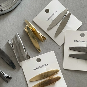 Détail de barrettes en métal brossé doré, argenté et gris sur cartes de support