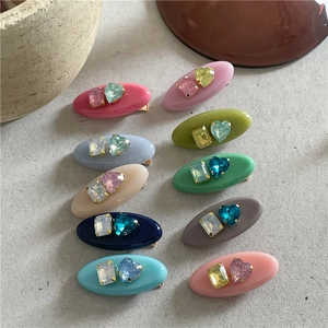 Détail de barrettes en résine avec strass colorés aux tons rétro assortis