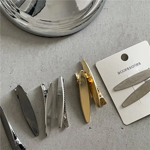 Gros plan sur des barrettes minimalistes en alliage brossé aux finitions or et argent