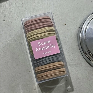 Close-up of colorful seamless elastic hair ties in a transparent rectangular storage box