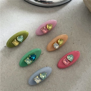 Détail de 6 barrettes colorées en acrylique avec strass en forme de cœur et carrés