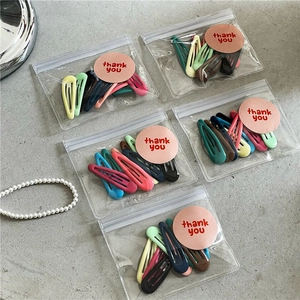 Détail des lots de 10 barrettes goutte colorées dans un emballage cadeau élégant