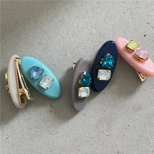 Vue détaillée de cinq barrettes colorées en résine avec des strass brillants en forme de cœur