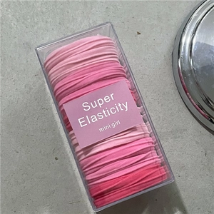 Detailed set of pink elastic hair bands in a transparent storage box for daily styling