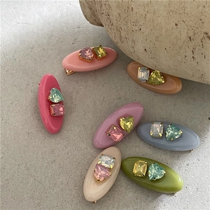 Lot de barrettes à strass colorés avec pierres géométriques cœur et carrées sur fond pierre