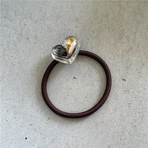 Détail d'un élastique à cheveux marron avec cristaux de strass contrastés en cœur