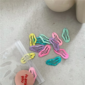 Detailed view of colorful heart-shaped polka dot hair clips with thank you packaging