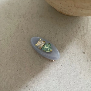 Vue détaillée d'une pince à cheveux lavande avec zircons rectangulaires et cœur vert