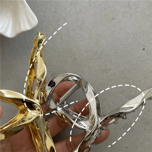 Close-up of gold and silver liquid metal hair claws with heavy-duty metal springs
