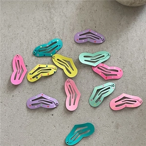 Detail of heart-shaped macaron metal hair clips in matte pastel colors and polka dot patterns
