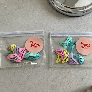 Detailed view of colorful polka dot BB hair clips in cute pink transparent packaging