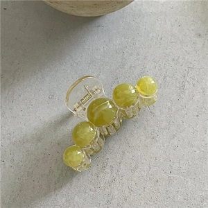 Vue détaillée de la pince à cheveux vert clair avec perles marbrées et ressort métallique