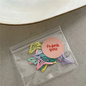 Macro shot of colorful pastel wave hair clips with polka dots in thank you packaging