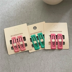 Nahaufnahme gewellter rechteckiger BB-Haarspangen in Pink, Grün und Magenta