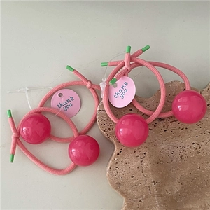 Pink elastic hair ties with red jelly beads and thank you tags on a stone plate