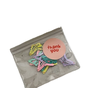 Set of cute wavy cream bow hairpins with colorful dots in a clear gift bag