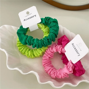 Four-piece set of vibrant pleated fabric scrunchies in pink and green with display cards