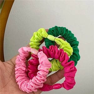 Set of four colorful pleated fabric hair scrunchies in pink and green shades