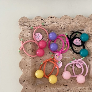 Colorful cream-toned hair ties with jelly beads on a stone tray for hair styling