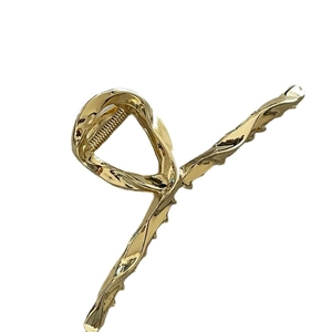 Minimalist large liquid metal hair claw clip in polished gold finish with fluid lines