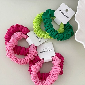 Detail of colorful satin scrunchies with pleated texture on white display cards