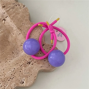 Macro detail of elastic hair ties with glossy purple sphere beads and pink thank you card