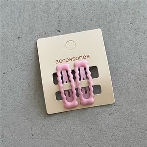Detail von rosa gewellten BB-Haarspangen mit Keramikglasur auf Displaykarte