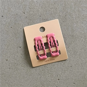 Detail von rosa wellenförmigen BB-Clips mit Handmade-Logo auf der Verpackung
