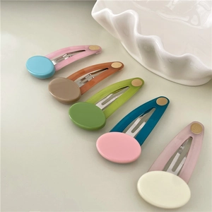 Detailed set of five colorful resin snap hair clips in matte pastel tones on a white tray