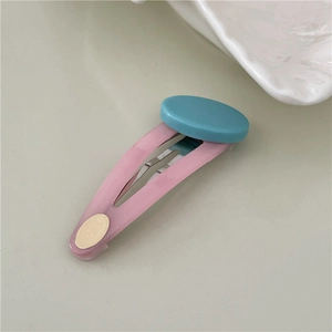 Detail of pink marble textured BB hair clip with a blue circular resin accent piece
