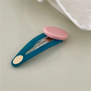Detail view of oval BB hair clip with pink resin patch and dark cyan jelly texture