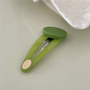 Close-up of green jelly texture BB hair clip with oval gold accent and metal base