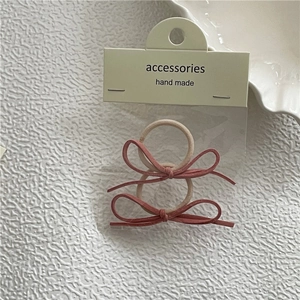 Detailansicht von 2er-Pack rosa Haargummis mit Wildleder-Schleifen in Verpackung