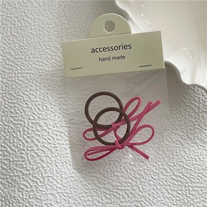 Detail eines zweiteiligen handgefertigten Haargummi-Sets mit Schleifen aus rosa Wildleder