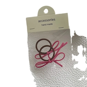 Zweiteiliges Set elastische Haargummis mit rosa Wildleder-Schleifen auf Display-Karte