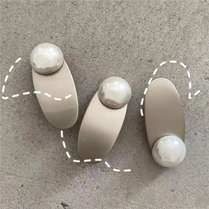 Detailed view of three minimalist silver hair clips with glossy faux mabe pearl hearts