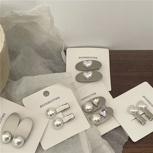 Macro detail of silver hair clips with pearls and rhinestones on a card set