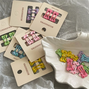 Mini barrettes colorées en forme d'os avec pois sur cartes d'affichage