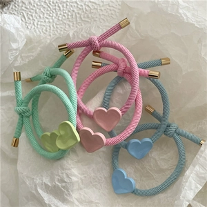 Close-up of pastel elastic hair ties with colorful twill texture and golden heart charms