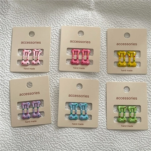 Lot de 12 mini barrettes en forme d'os avec pois colorés sur cartonnette