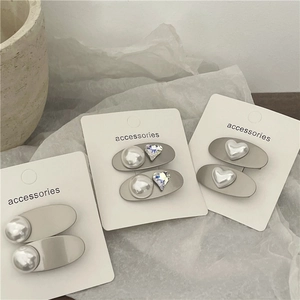 Silver hair clip set with Mabe pearl hearts and rhinestones on a white display card