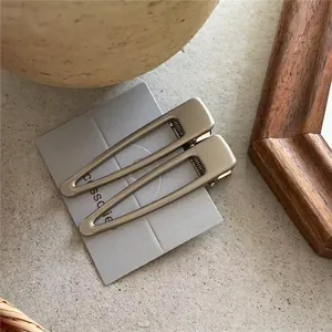 Detail of minimalist metallic wavy geometric hair clips on card with matte silver finish