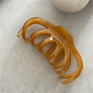 Macro view of a 13cm jelly texture hair claw clip in amber translucent resin