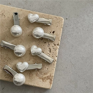 Silver alloy hair clip set with white heart and round faux pearls on a stone base