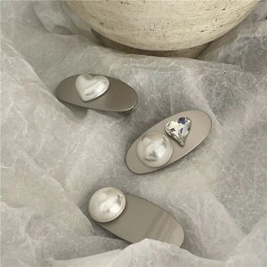 Detail of matte silver hair clip set with faux mabe pearls and heart crystal accents