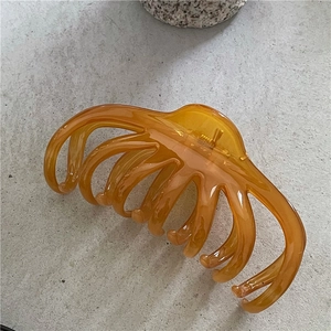 Detail of a large 13cm amber hair claw clip with jelly texture for thick hair styling