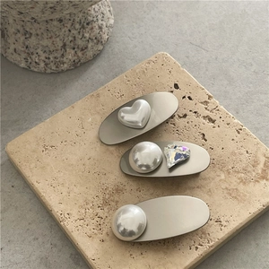 Detailed macro view of heart-shaped pearls and crystal embellishments on silver metal hair clips